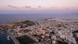 an aerial view of a city next to the ocean at Old Town Rhapsody, Cosy 2-Floor Home with Rooftop Bathtub, BBQ & Lounge Under Sun Umbrellas in Rethymno