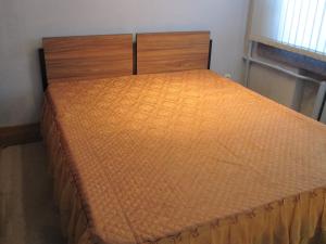 ヴォロネジにあるApartment Pushkinskaya 35のオレンジ色のベッドカバーが備わるベッドルームのベッド1台分です。