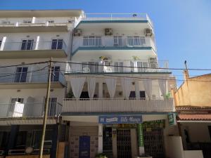 a large white building with balconies on a street at Hostal Villa Maruja in El Arenal
