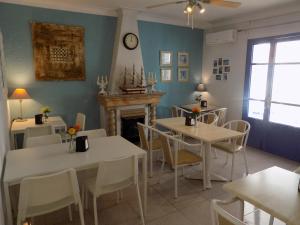 a dining room with tables and chairs and a fireplace at Hostal Villa Maruja in El Arenal