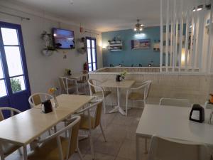 a restaurant with tables and chairs and a counter at Hostal Villa Maruja in El Arenal