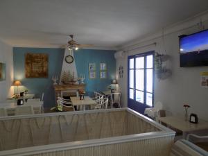 a room with tables and chairs and a tv on the wall at Hostal Villa Maruja in El Arenal