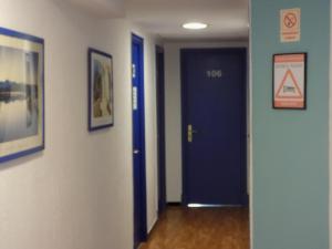 a hallway with a blue door and signs on the walls at Hostal Villa Maruja in El Arenal