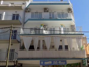 a building with white balconies and white curtains on it at Hostal Villa Maruja in El Arenal