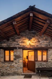a stone house with a large wooden roof at Fogar Mozárabe in Peñalba de Santiago