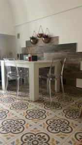 a dining room with a table and chairs on a rug at Vicolo 4 Locazione Turistica in Monopoli