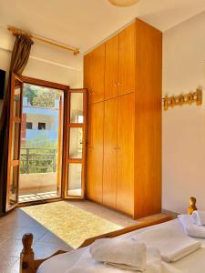 a bedroom with a large wooden cabinet and a bed at Marinos Studios and Apartments in Gialiskari