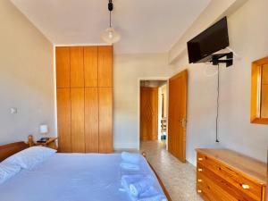 a bedroom with a bed and a tv on the wall at Marinos Studios and Apartments in Gialiskari