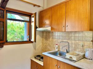 a kitchen with a sink and a window at Marinos Studios and Apartments in Gialiskari