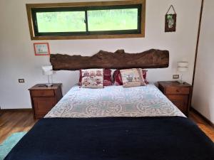 Un dormitorio con una cama grande con dos mesitas de noche. en Eco Brújula II, en Villarrica
