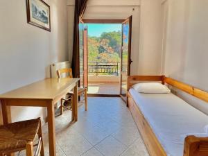a room with a bed and a desk and a table at Marinos Studios and Apartments in Gialiskari