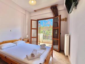 a bedroom with a bed with towels on it at Marinos Studios and Apartments in Gialiskari