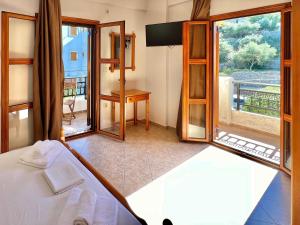 a bedroom with a bed and a view of a balcony at Marinos Studios and Apartments in Gialiskari