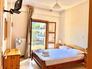 a bedroom with a bed and a window at Marinos Studios and Apartments in Gialiskari