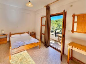 a bedroom with a bed and a balcony at Marinos Studios and Apartments in Gialiskari