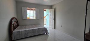 a room with a bed and a window and a door at Vila Mar Flats - 1 Dorm - Guriri - 800m da Praia in Guriri