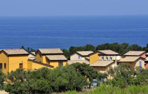 un groupe de maisons sur une colline près de l'océan dans l'établissement Les Terrasses de LOZARI de Nadine et Claude, à Belgodère