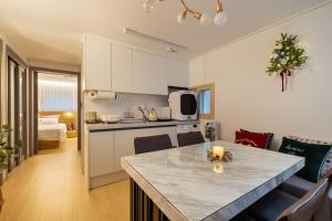 a kitchen and living room with a table in a room at Choi's Stay HongDae in Seoul