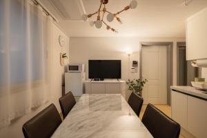 a dining room with a table and chairs and a television at Choi's Stay HongDae in Seoul