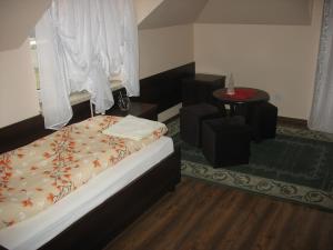 Dormitorio pequeño con cama y mesa en Willa Viola, en Busko-Zdrój