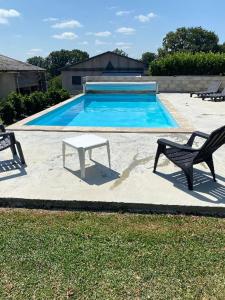 a pool with a bench and a table in front of it at Chez Pépé et Moumoune in Rignac