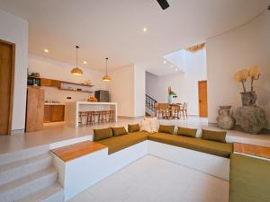 an open living room with a couch and a kitchen at Miko Villa Seminyak in Seminyak