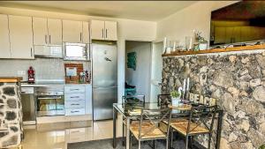 コスタ・テギセにあるBeach Houseの石壁のキッチン(テーブル付)