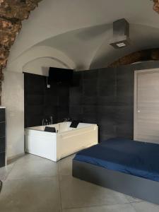 a bedroom with a tub and a bed and a tv at HomeSuite45 in Catania