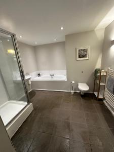 a bathroom with a tub and a toilet and a sink at Woodfalls Luxury Getaway in Bournemouth