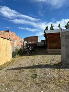 una motocicleta estacionada en un patio al lado de un edificio en Hospedaje al Fondo, en Gobernador Gregores