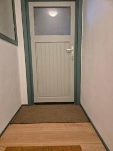 a hallway with a white door with a rug at Guesthouse Wallenborn - Appartement in Wallenborn