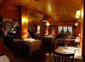 une salle à manger avec des tables et des chaises dans un restaurant dans l'établissement Hotel Els Puis, à Esterri d'Àneu