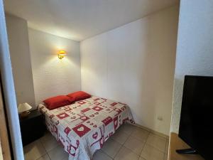 a small bedroom with a bed with a red blanket at Charmant appartement Termignon 4 pers, 27m² avec Wifi - FR-1-508-305 in Val Cenis