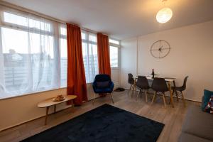 a living room with a table and chairs and windows at Entire 3 Bedroom Apartment in Felixstowe in Felixstowe