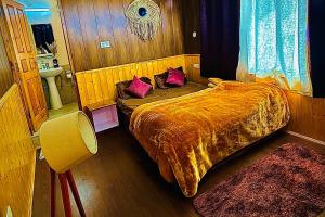 una camera da letto con un letto con cuscini viola di The Ivy Mansion Sethan a Manāli