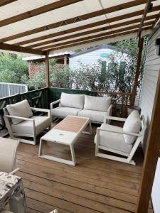 a patio with couches and a coffee table on a deck at Camping Del Mar 265, Mobile Home Excellence, 3 chambres, 6 personnes, 2 Salles de Bain, bord de mer in Argelès-sur-Mer