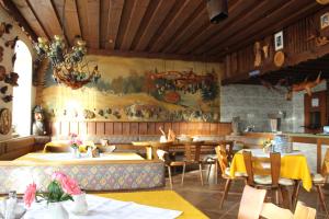 a restaurant with tables and chairs and a painting on the wall at Ferienwohnungen Ludwigsthal in Ludwigsthal
