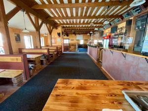 an empty restaurant with a bar and wooden tables at Johannova Bouda in Vrchlabí