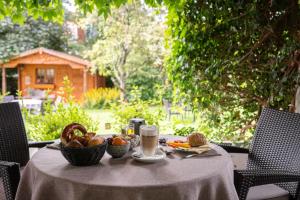 a table with a bowl of fruit and a glass of milk at Hotel Filser in Füssen