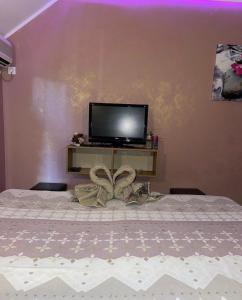 a bedroom with a bed with a tv on a table at Dreams Rooms in Dušanovac (historical) +8 photos