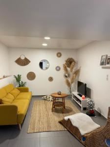 a living room with a yellow couch and a table at L'Entre-Temps in Xhendelesse