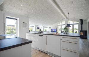 una cucina con mobili bianchi e un piano di lavoro nero di Holiday Home Lakolk Rømø Denmark a Bolilmark