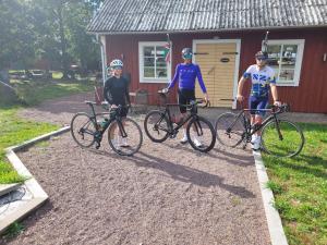 three people standing with their bikes in front of a house at Rugstorps Lantgårds Glamping in Rockneby