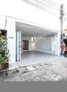 a white building with an open door and a courtyard at Muji house near Central festival chiangmai in Chiang Mai