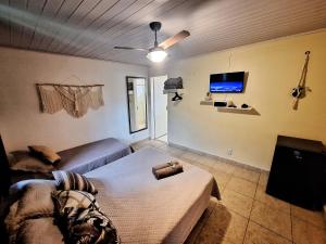 a bedroom with a bed and a flat screen tv at Pousada do Coco in Abraão