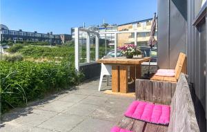 ein Balkon mit einem Tisch und rosa Kissen in der Unterkunft Berg En Zee 4 in Bergen aan Zee