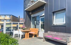 eine Terrasse mit einem Tisch und einer Bank auf einem Balkon in der Unterkunft Berg En Zee 4 in Bergen aan Zee