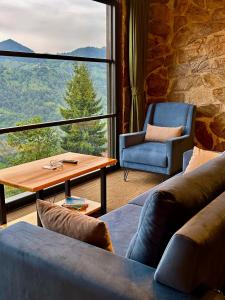 a living room with a couch and a table and a window at Alfa Dağevleri in Rize