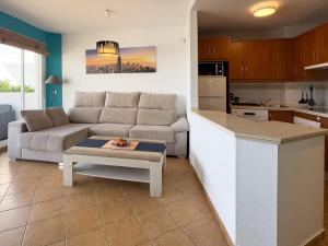 a living room and kitchen with a couch and a table at Apartamento El Barco 1 linea PLAYA, PARKING, WIFI in Torrox Costa