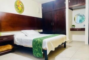 ein Schlafzimmer mit einem Bett mit hölzernem Kopfteil in der Unterkunft Casa Hotel Marchel in Tequila